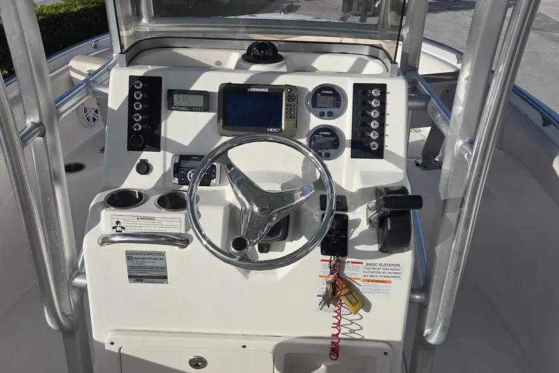 Slide: The Image of 2016 Robalo R222 Center Console boat dashboard with steering wheel and navigation controls. - 11