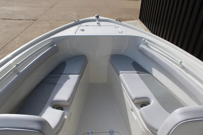 Slide: The Image of 2025 Mako 214 Center Console boat interior with cushioned seating and storage compartments. - 10