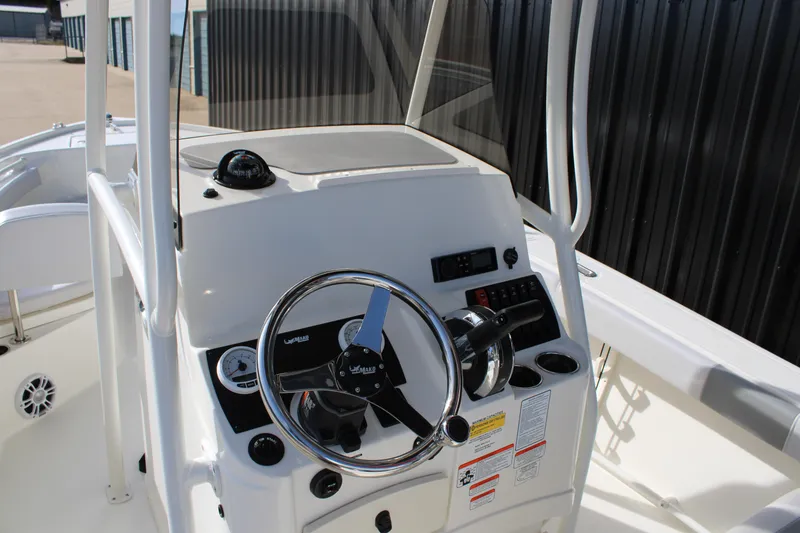 Slide: The Image of 2025 Mako 214 Center Console boat dashboard with steering wheel and controls. - 13
