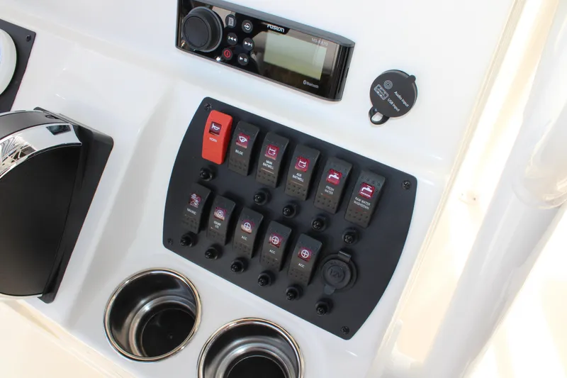 Slide: The Image of Control panel of 2025 Mako 214 Center Console boat with switches and cup holders. - 19
