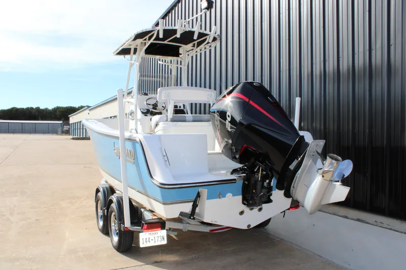 Slide: The Image of 2025 Mako 214 Center Console boat with powerful outboard motor, parked on trailer. - 6