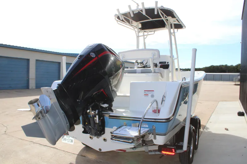 Slide: The Image of 2025 Mako 214 Center Console boat with powerful outboard motor, parked on trailer. - 7