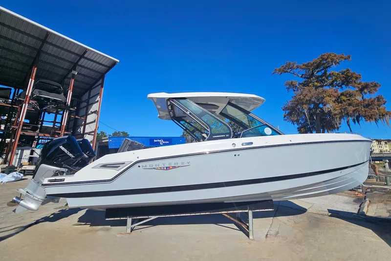 Slide: The Image of 2026 Monterey Elite 30 OB boat displayed outdoors under clear blue sky. - 2