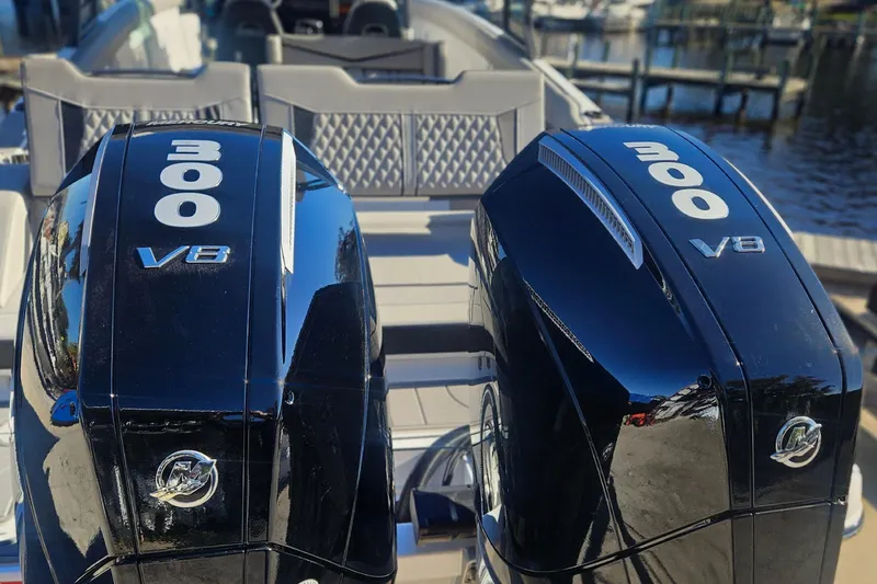 Slide: The Image of Twin 300 V8 engines on a 2026 Monterey Elite 30 OB boat at a marina. - 4
