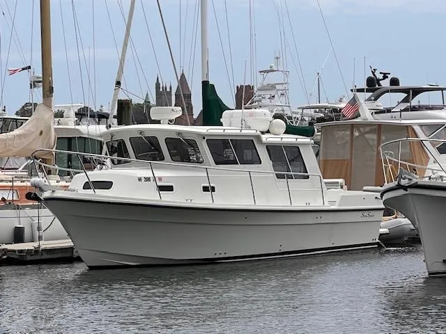 The Image of 2004 Sea Sport Voyager 3000 boat docked in a marina. - 0