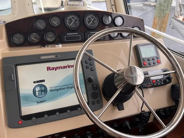Slide: The Image of 2004 Sea Sport Voyager 3000 helm with Raymarine navigation display and steering wheel. - 12
