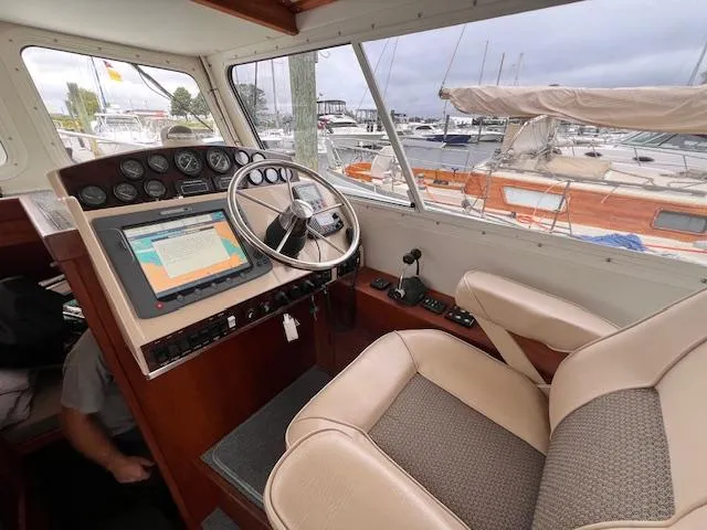 Slide: The Image of 2004 Sea Sport Voyager 3000 helm with navigation system and marina view. - 13