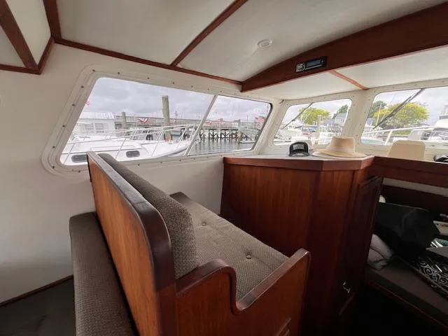 Slide: The Image of Interior of 2004 Sea Sport Voyager 3000 boat with wooden seating and large windows. - 14