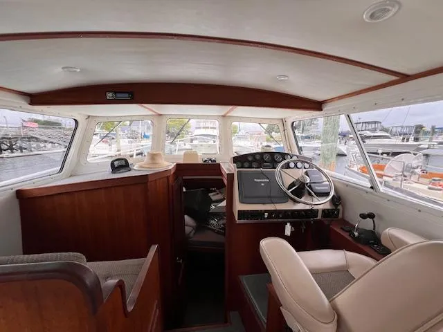 Slide: The Image of Interior of 2004 Sea Sport Voyager 3000 boat, featuring helm and seating area. - 15