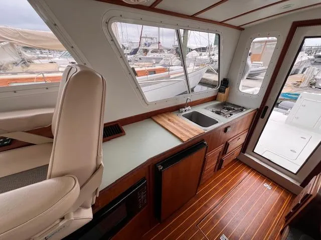 Slide: The Image of Interior of 2004 Sea Sport Voyager 3000 boat with kitchenette and seating area. - 17