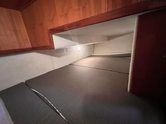 Slide: The Image of Interior cabin of 2004 Sea Sport Voyager 3000 boat, featuring wood paneling and cozy sleeping area. - 21