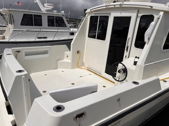 Slide: The Image of 2004 Sea Sport Voyager 3000 boat docked, featuring spacious deck and modern design. - 4