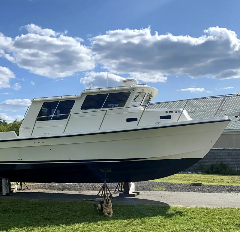 Slide: The Image of 2004 Sea Sport Voyager 3000 boat on land under a blue sky. - 6