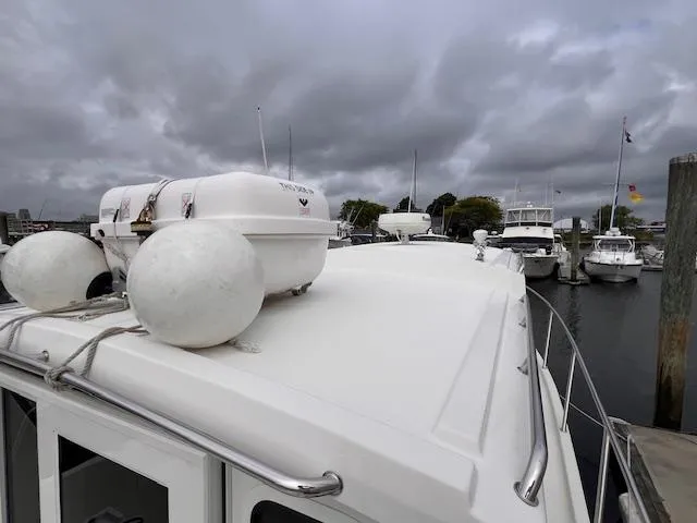Slide: The Image of 2004 Sea Sport Voyager 3000 docked at marina under cloudy skies. - 7