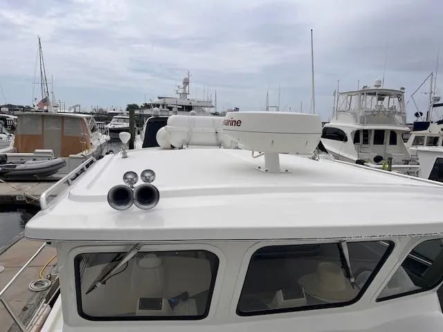Slide: The Image of 2004 Sea Sport Voyager 3000 boat docked in a marina, featuring radar and horn on the roof. - 9