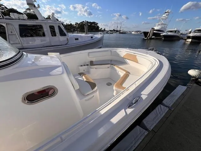 Slide: The Image of 2015 Edgewater 280CC boat docked, featuring spacious seating and sleek design. - 7