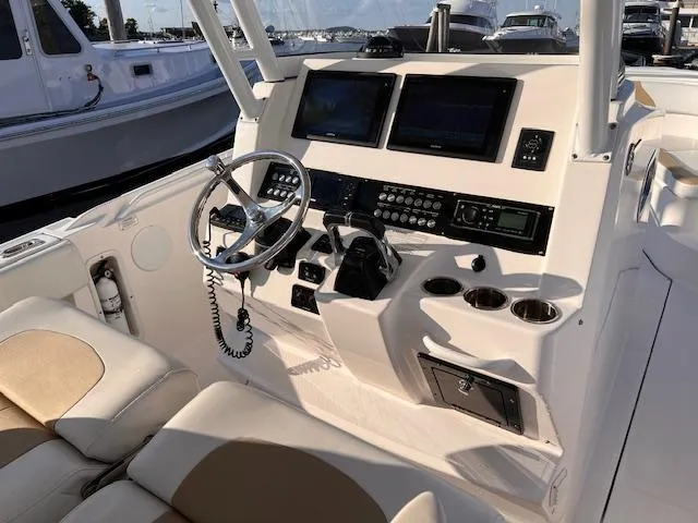 Slide: The Image of 2015 Edgewater 280CC boat cockpit with steering wheel and navigation controls. - 9