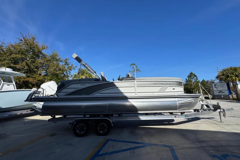 Slide: The Image of 2026 Bennington 24 MFB pontoon boat on trailer under clear blue sky. - 10