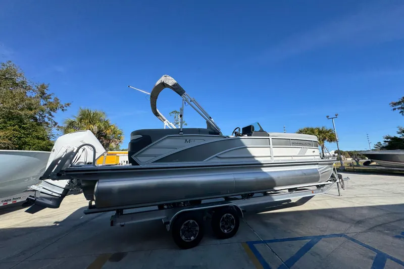Slide: The Image of 2026 Bennington 24 MFB pontoon boat on trailer under clear blue sky. - 11