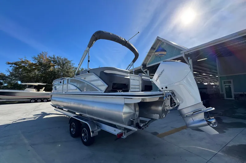 Slide: The Image of 2026 Bennington 24 MFB pontoon boat with Mercury outboard engine on trailer. - 16