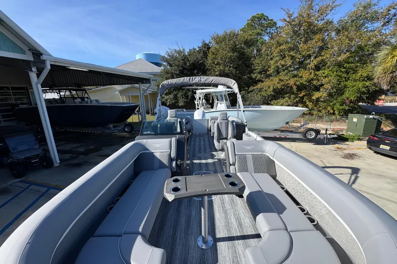 Slide: The Image of 2026 Bennington 24 MFB pontoon boat with spacious seating and modern design in a marina setting. - 18
