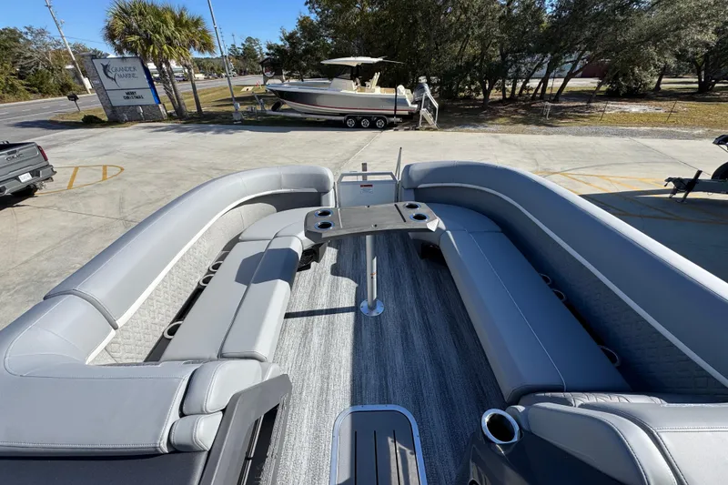 Slide: The Image of 2026 Bennington 24 MFB pontoon boat with spacious seating and table, parked outdoors. - 22