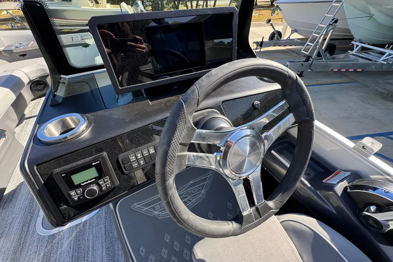 Slide: The Image of 2026 Bennington 24 MFB boat dashboard with steering wheel and control panel. - 24