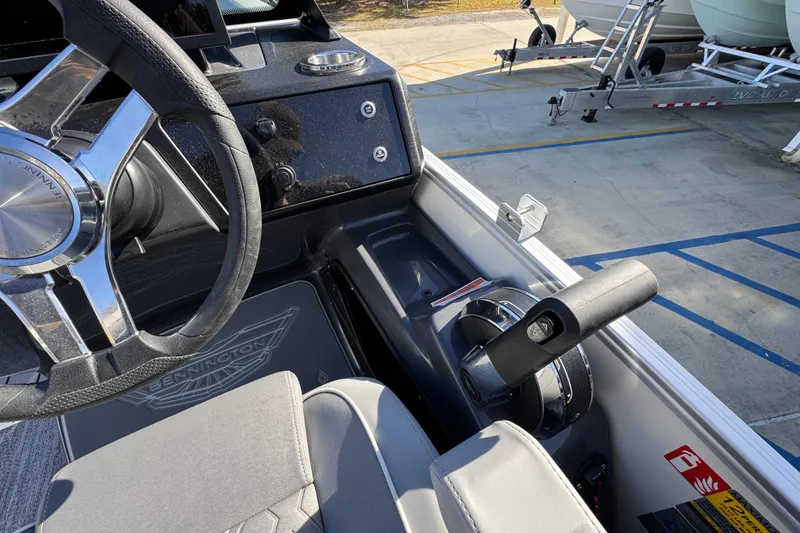 Slide: The Image of 2026 Bennington 24 MFB boat steering wheel and throttle control in a marina setting. - 26