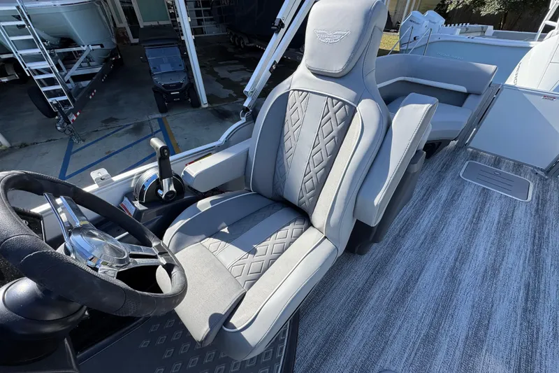 Slide: The Image of 2026 Bennington 24 MFB boat interior with luxury captain's chair and steering wheel. - 27