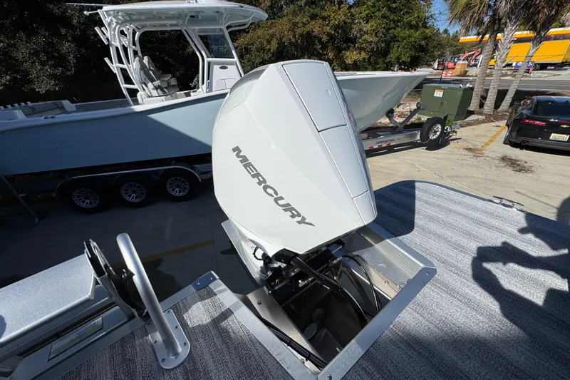 Slide: The Image of 2026 Bennington 24 MFB boat with Mercury outboard motor in a parking lot. - 37