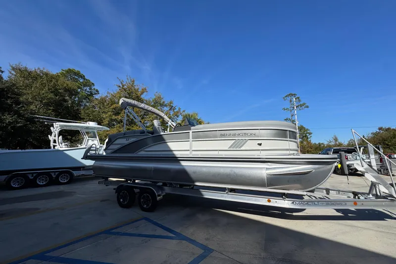 Slide: The Image of 2026 Bennington 24 MFB pontoon boat on trailer under clear blue sky. - 9