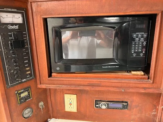 Slide: The Image of 2001 Carolina Classic 28 boat interior with microwave and control panel. - 11