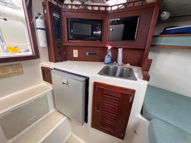 Slide: The Image of 2001 Carolina Classic 28 boat interior with kitchenette, microwave, sink, and mini-fridge. - 9