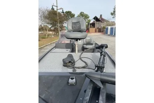 Slide: The Image of 2021 Bass Tracker Classic boat with seating and equipment, parked outdoors. - 5