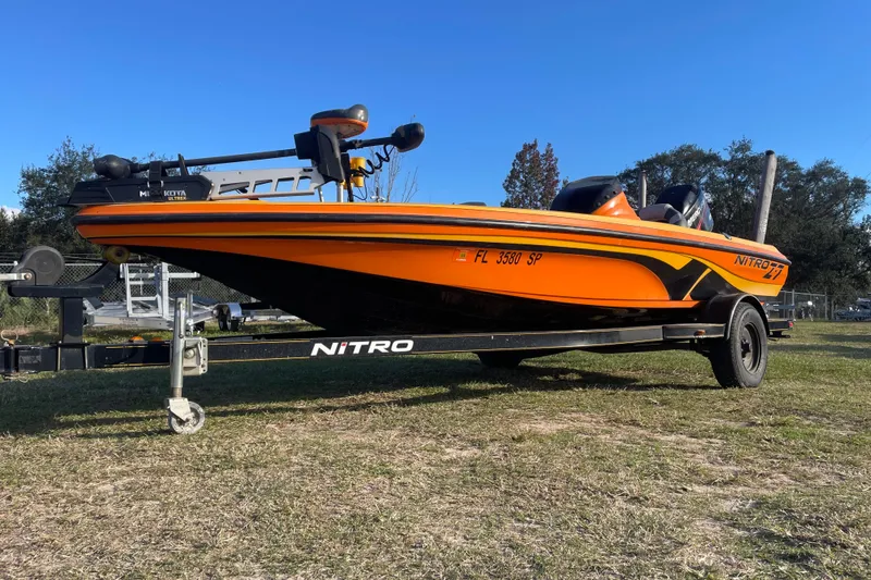 Slide: The Image of Orange 2008 Nitro Z-7 boat on trailer, parked on grass under clear blue sky. - 1