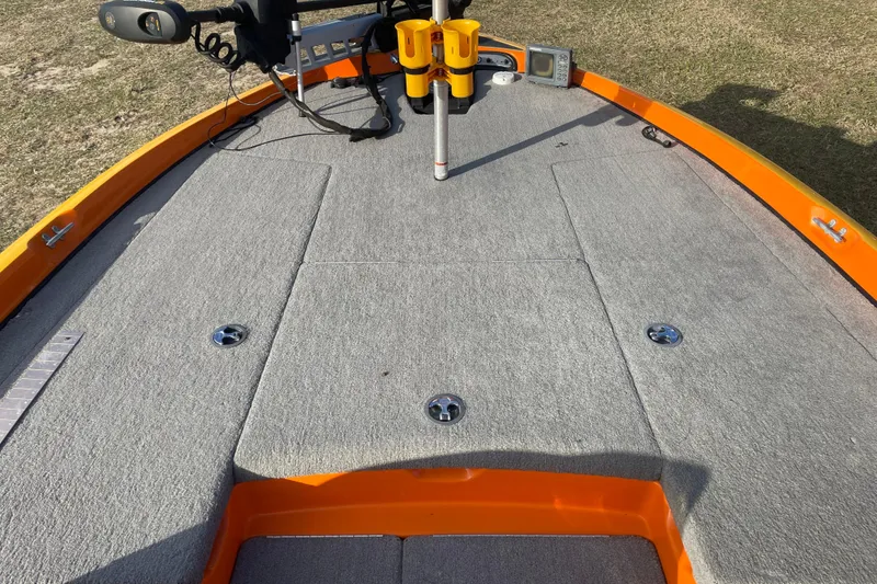 Slide: The Image of 2008 Nitro Z-7 boat deck with gray carpet and orange trim, featuring fishing equipment. - 10