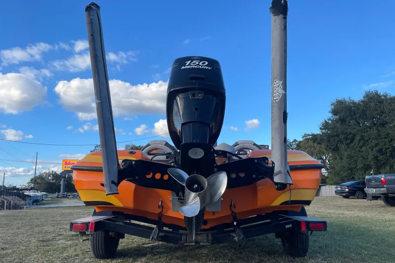 Slide: The Image of 2008 Nitro Z-7 boat with Mercury 150 engine, parked on grass under blue sky. - 4