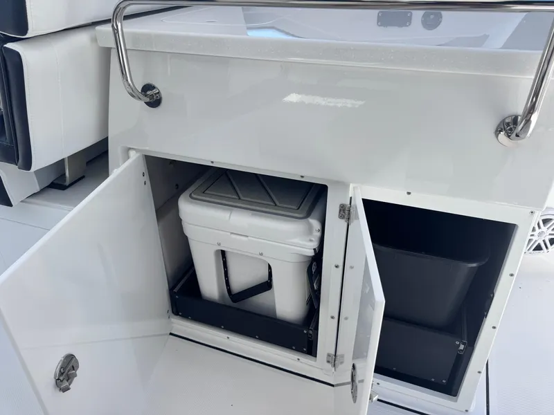 Slide: The Image of 2026 Blackfin 272 DC boat storage compartment with cooler and trash bin. - 17