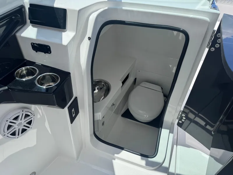 Slide: The Image of 2026 Blackfin 272 DC boat interior with toilet and cup holders. - 19