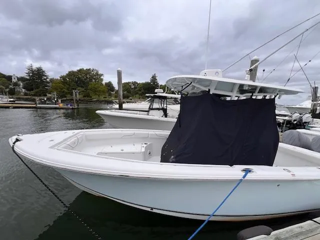 Slide: The Image of 2015 Sea Hunt Gamefish 25 boat docked in a marina under cloudy skies. - 2
