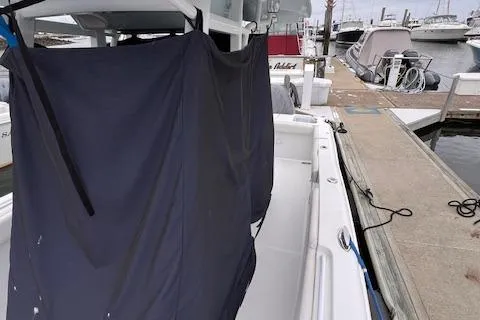 Slide: The Image of 2015 Sea Hunt Gamefish 25 boat docked, covered with a dark tarp. - 5