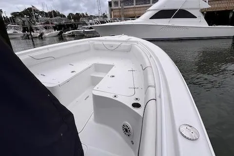 Slide: The Image of 2015 Sea Hunt Gamefish 25 boat docked in marina, showcasing spacious deck and sleek design. - 8