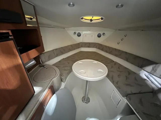 Slide: The Image of 2005 Hydra-Sports 2500 VX cabin interior with seating, table, and storage. - 7