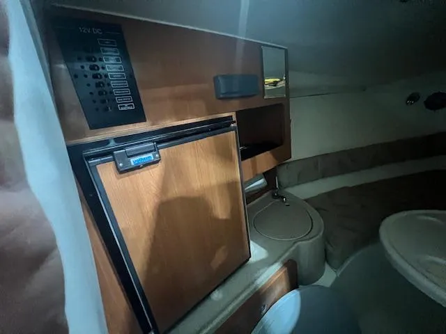 Slide: The Image of 2005 Hydra-Sports 2500 VX cabin interior with wood paneling and compact amenities. - 8