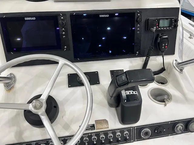 Slide: The Image of Control panel of a 1997 Silverhawk 24 CC boat with Simrad displays and steering wheel. - 5