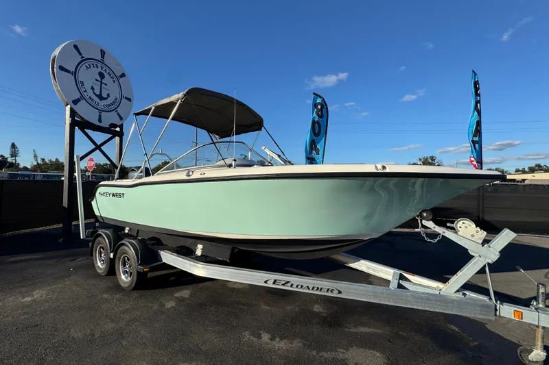 The Image of 2021 Key West 203 DFS boat on trailer at dealership under clear blue sky. - 0