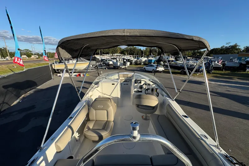 Slide: The Image of 2021 Key West 203 DFS boat with canopy, parked in a marina under clear blue sky. - 15