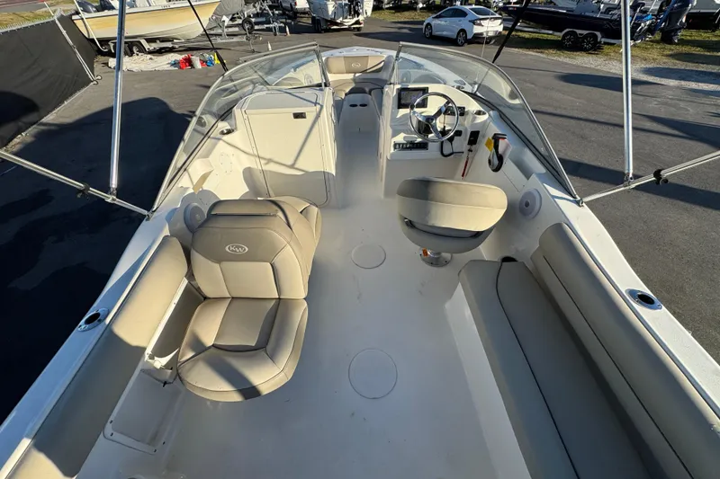Slide: The Image of 2021 Key West 203 DFS boat interior with seating and steering wheel, parked outdoors. - 17