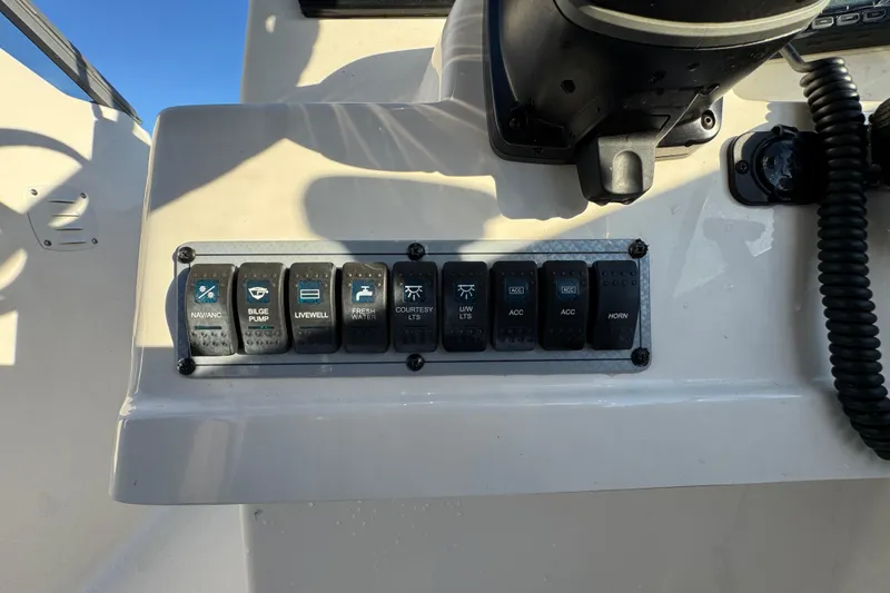 Slide: The Image of Control panel of a 2021 Key West 203 DFS boat with various switches. - 23