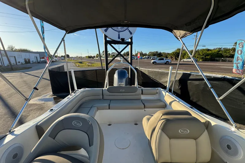 Slide: The Image of 2021 Key West 203 DFS boat interior with seating and canopy, parked outdoors. - 46